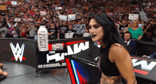 a woman in a black top is standing in front of a sign that says prime