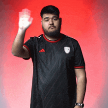 a man with a beard wearing a black adidas shirt