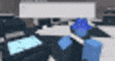 a blurry picture of a person wearing a blue hat standing in front of a computer .