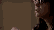a close up of a woman wearing glasses and a hood .