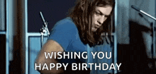 a man with long hair is playing a guitar and says `` wishing you a happy birthday '' .