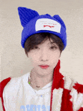 a boy wearing a blue knitted hat and a white shirt with the word avatar on it