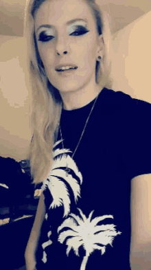 a woman is wearing a black shirt with a palm tree on it