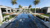 a large swimming pool surrounded by palm trees