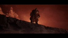 a man in armor is standing on top of a rock