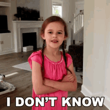 a little girl in a pink dress with her arms crossed says i don t know