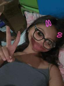 a girl wearing glasses and making a peace sign with her fingers