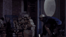 a man in a baseball cap is standing in front of a building with his arms in the air .