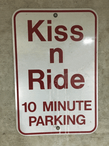 a red and white sign says kiss n ride 10 minute parking