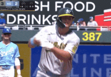 a baseball player is swinging at a ball in front of a sign that says drinks