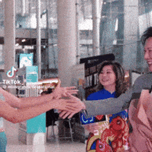 a man and a woman are shaking hands in an airport