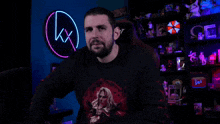 a man sitting in front of a neon sign that says wanted