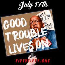 a sign that says good trouble lives on is held up by a hand