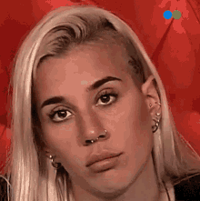 a close up of a woman 's face with a red background