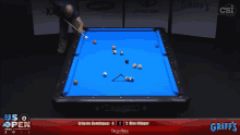 a pool table with a blue cloth and a man holding a pool cue