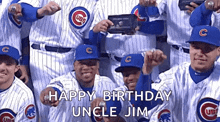 a group of cubs baseball players are holding up their rings and celebrating their birthday .