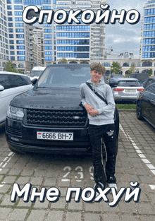 a young man stands in front of a range rover