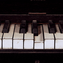 a close up of a piano keyboard with the word boston on the top left