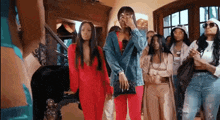 a group of women are standing in a room looking at something .