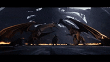 a person standing next to a large monster with fire behind it