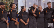 a group of people standing in front of a sign that says bravo on it