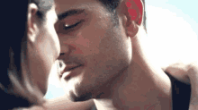 a man and a woman are kissing and the woman is kissing the man on the cheek .