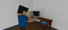 a man in a blue shirt is standing next to a computer