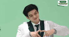 a man making a heart shape with his hands in front of a grabfood sign