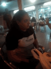 a person wearing a pull & bear shirt is sitting in a chair