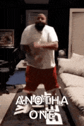 a man is dancing on a table in a living room with the words another one written on it .