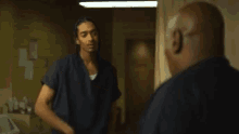 two men are standing next to each other in a hallway .