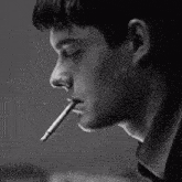 a man is smoking a cigarette and writing on a piece of paper .