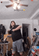 a man is dancing in a room with a ceiling fan and the words dance break on the bottom