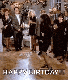 a woman is dancing on a dance floor at a birthday party with a group of people .