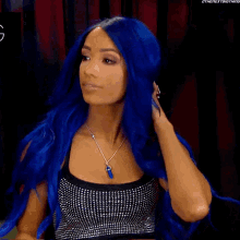 a woman with blue hair is wearing a black top and a necklace