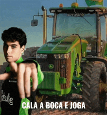a man pointing in front of a john deere tractor
