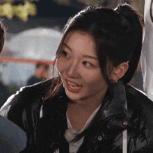 a close up of a woman wearing a black jacket and a white shirt