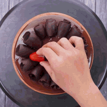 a person is decorating a chocolate cake with a strawberry