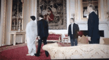 a group of people are standing in a living room with a couch .