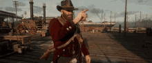a man in a cowboy hat is pointing at something in a video game