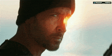 a close up of a man 's face with the sun behind him and the words pranay varma below him