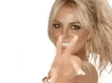 britney spears is making a peace sign with her hands .