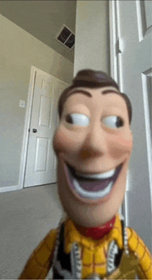 a woody doll is smiling in front of a white door
