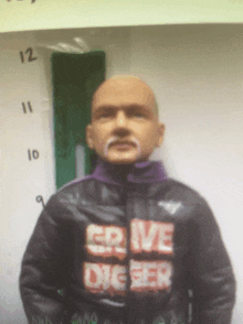 a bald man with a mustache is wearing a black jacket that says " crave digger "
