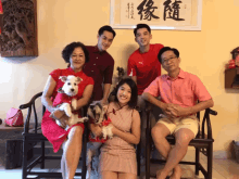 a group of people posing for a picture with chinese characters on the wall behind them