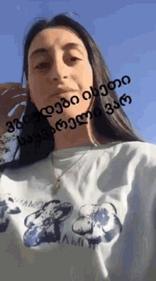 a woman wearing a white t-shirt with a picture of a bear on it