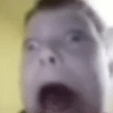 a close up of a person 's face with a shocked look on their face .