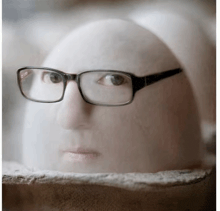 a statue of a man wearing glasses looks at the camera
