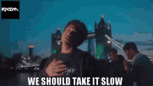 a group of people standing in front of a bridge with the words " we should take it slow "