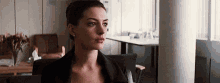 a woman in a black jacket is sitting in a chair in a room .